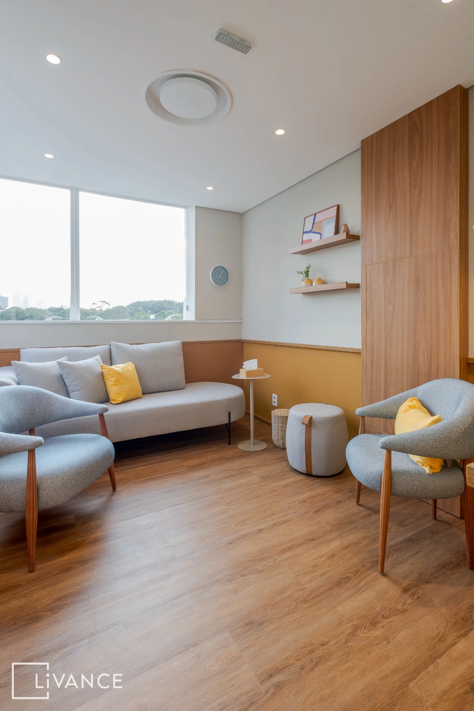 Sala de atendimento com sofá, poltronas e luz natural suave
